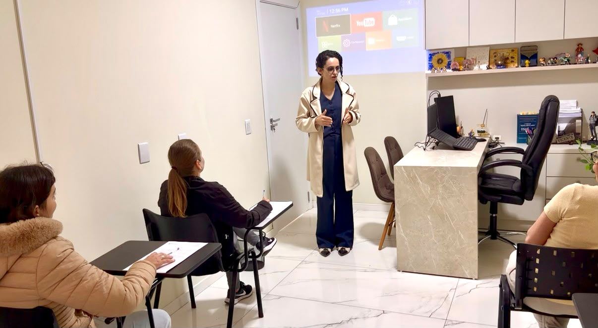 A psicóloga Aline Vicente conduzindo uma aplicação coletiva de testes (participantes ilustrativos)